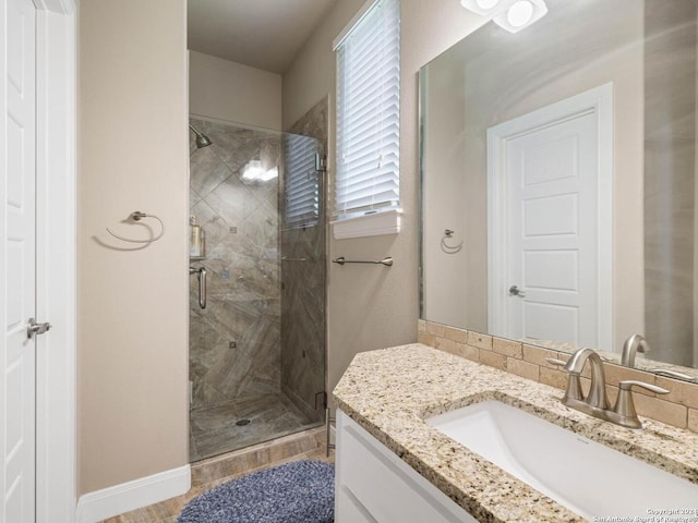 bathroom with hardwood / wood-style floors, vanity, and a shower with shower door