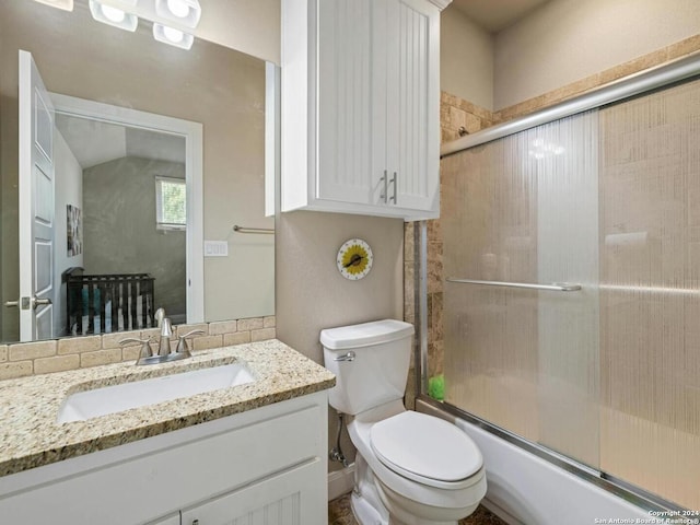 full bathroom with vanity, bath / shower combo with glass door, and toilet