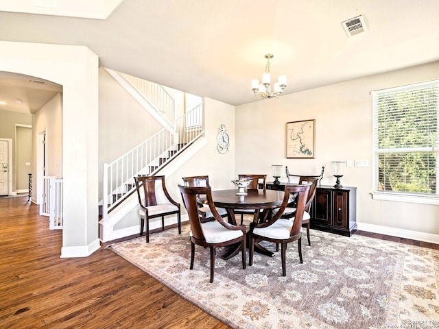 dining room with hardwood / wood-style floors and a chandelier