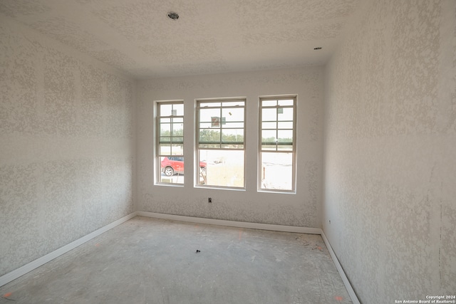 unfurnished room with concrete flooring and a textured ceiling