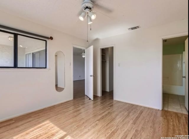 empty room with light wood-type flooring and ceiling fan