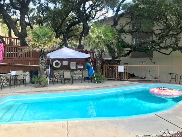 view of swimming pool with a gazebo, a wooden deck, and a patio area