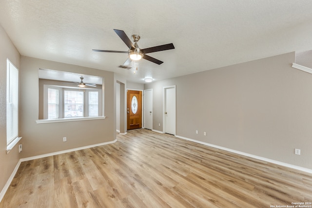 interior space featuring ceiling fan, a textured ceiling, and light wood-type flooring