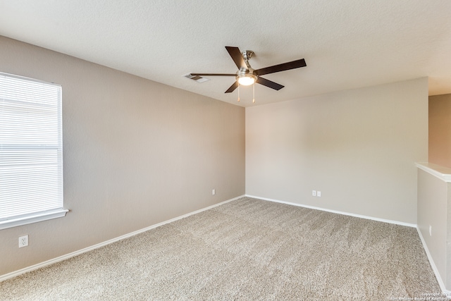 unfurnished room with ceiling fan, a textured ceiling, and carpet