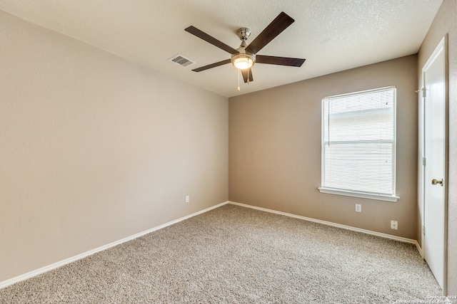 carpeted empty room featuring a textured ceiling and ceiling fan