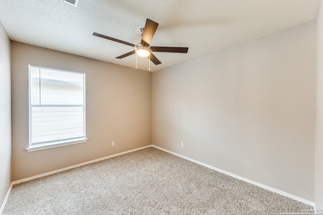 carpeted spare room featuring ceiling fan and a textured ceiling