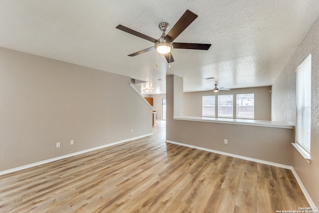 unfurnished living room with ceiling fan, light hardwood / wood-style floors, and a textured ceiling