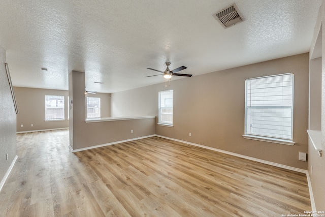 unfurnished room featuring ceiling fan, light hardwood / wood-style floors, and a textured ceiling