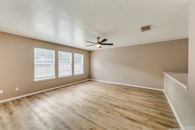 unfurnished room featuring light hardwood / wood-style floors and a textured ceiling