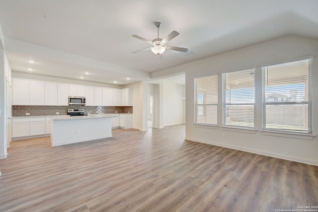 kitchen with ceiling fan, light hardwood / wood-style flooring, backsplash, white cabinetry, and appliances with stainless steel finishes