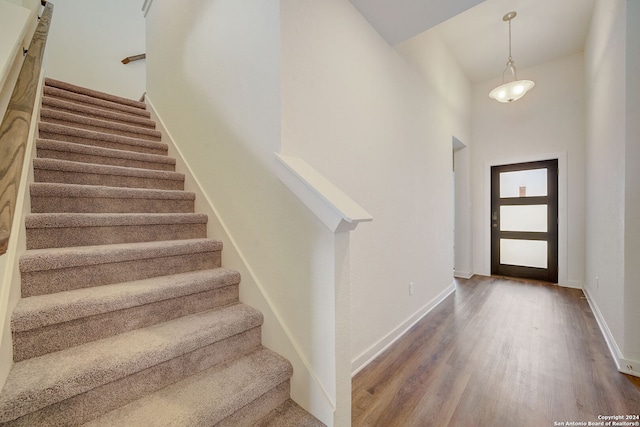 entrance foyer featuring a towering ceiling and hardwood / wood-style floors