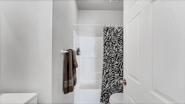 bathroom with shower / tub combo and toilet