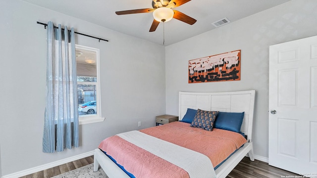 bedroom with dark hardwood / wood-style flooring and ceiling fan