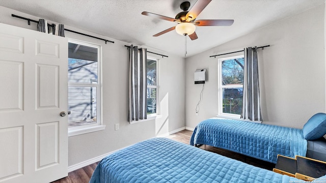 bedroom with ceiling fan, a textured ceiling, vaulted ceiling, and wood-type flooring