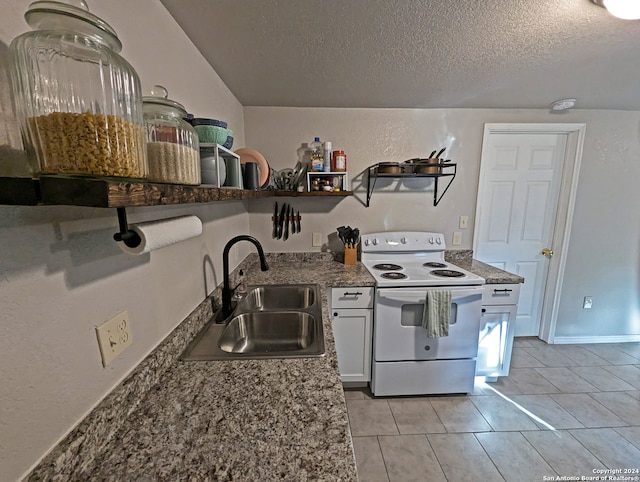 kitchen with light tile patterned floors, sink, a textured ceiling, white cabinetry, and electric range