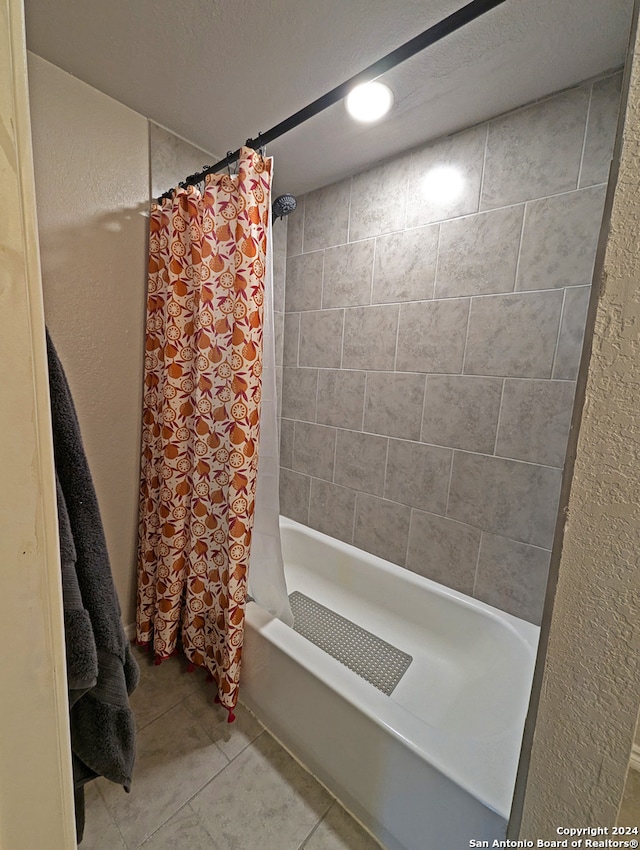 bathroom with shower / bath combination with curtain, tile patterned flooring, and a textured ceiling