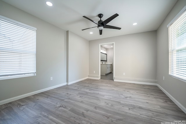 unfurnished bedroom with ceiling fan, ensuite bath, and light hardwood / wood-style floors