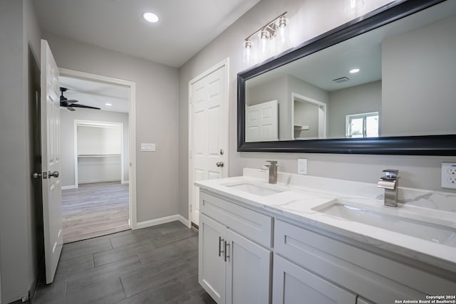 bathroom with wood-type flooring, vanity, and ceiling fan