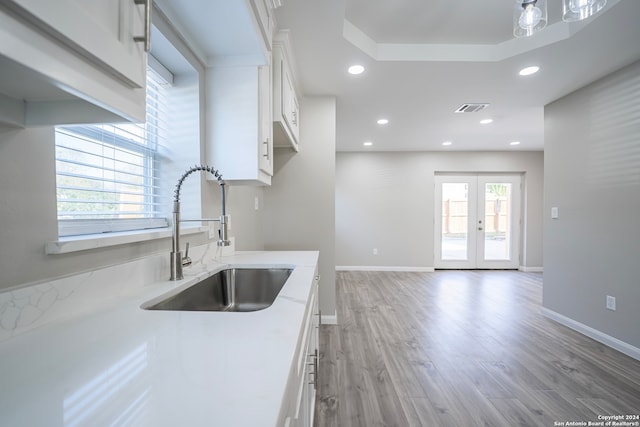 kitchen featuring french doors, light hardwood / wood-style floors, white cabinets, and sink