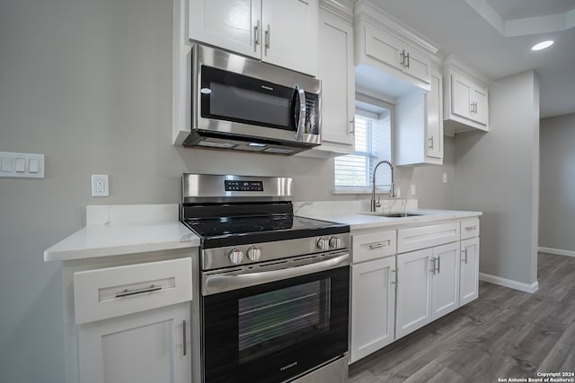 kitchen featuring stainless steel appliances, dark wood-type flooring, sink, and white cabinetry