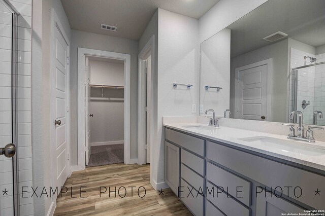 bathroom featuring vanity, an enclosed shower, and wood-type flooring