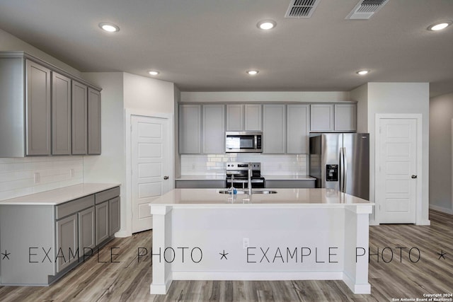 kitchen featuring stainless steel appliances, light hardwood / wood-style flooring, sink, and gray cabinetry