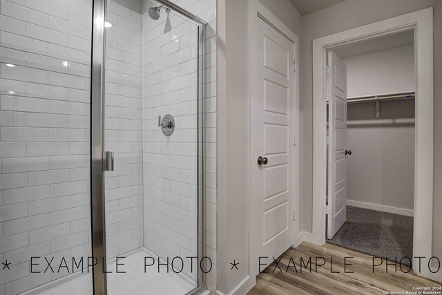 bathroom with wood-type flooring and walk in shower