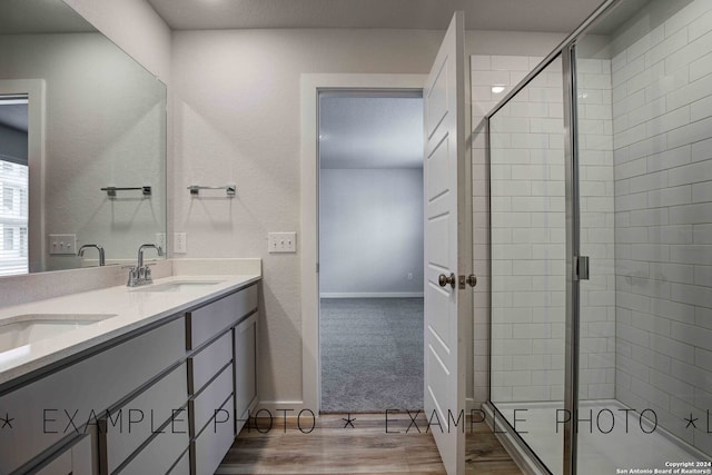 bathroom featuring vanity, hardwood / wood-style flooring, and a shower with door