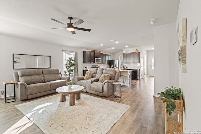 living room featuring ceiling fan and light hardwood / wood-style flooring