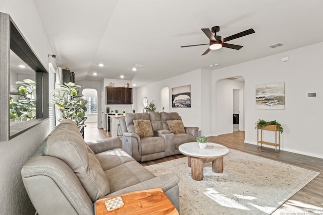 living room with light wood-type flooring and ceiling fan