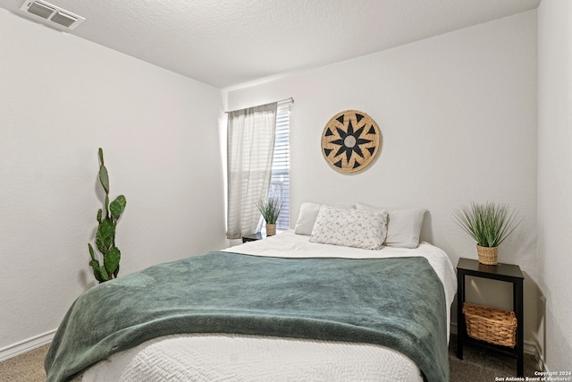 bedroom with carpet floors and a textured ceiling