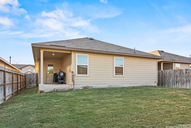 back of house featuring a yard and a patio area