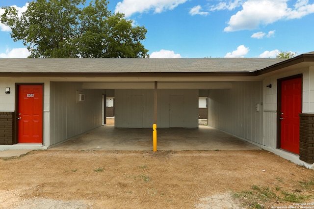 garage featuring wooden walls and a carport