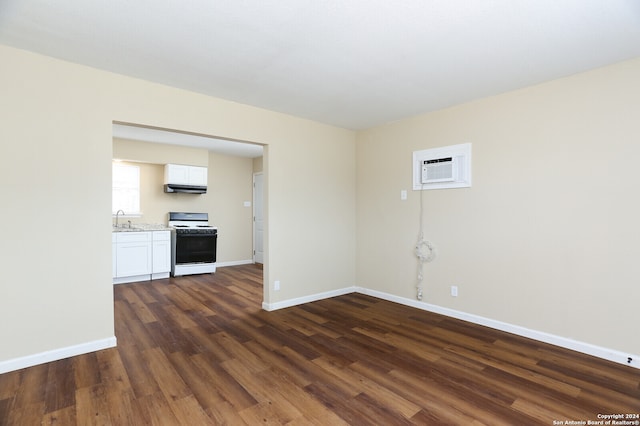 spare room with a wall mounted air conditioner, sink, and dark hardwood / wood-style floors