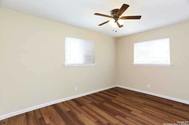 spare room featuring ceiling fan and dark wood-type flooring