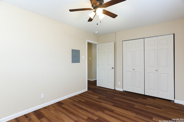 unfurnished bedroom with electric panel, ceiling fan, dark wood-type flooring, and a closet