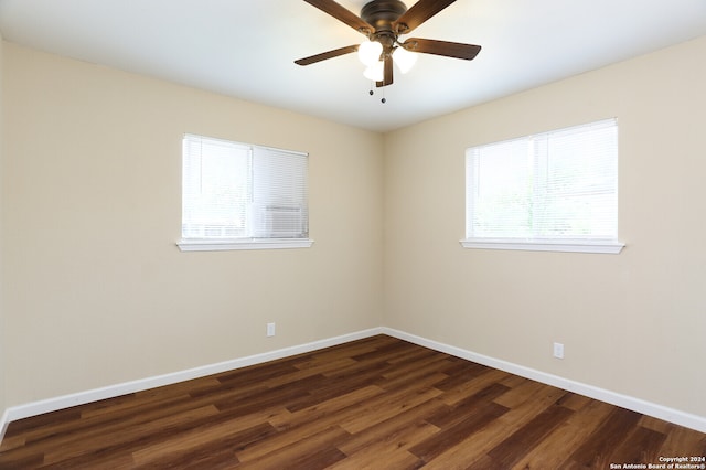 empty room featuring dark wood-type flooring and ceiling fan