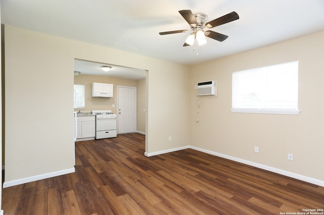 spare room with ceiling fan, dark wood-type flooring, and an AC wall unit