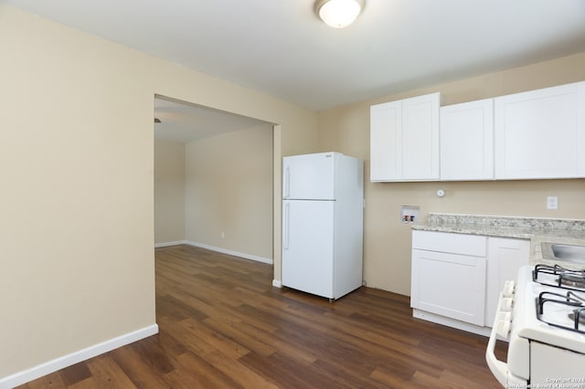 kitchen featuring light stone counters, dark hardwood / wood-style flooring, white appliances, and white cabinets