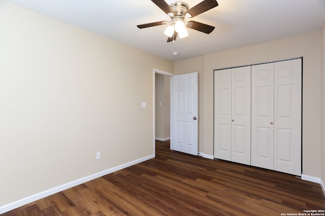 unfurnished bedroom featuring dark wood-type flooring, a closet, and ceiling fan