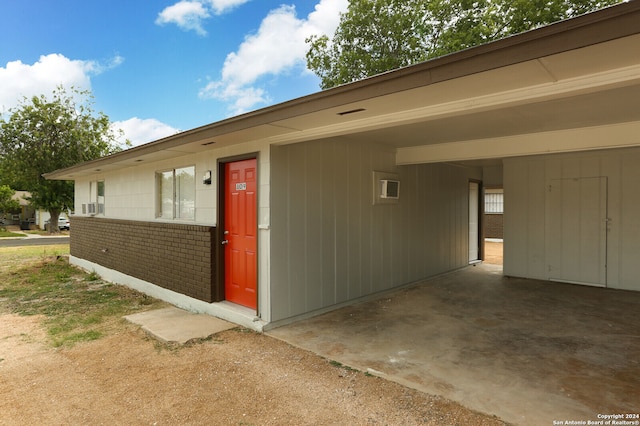 doorway to property featuring cooling unit and a carport