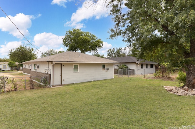 rear view of property featuring a lawn