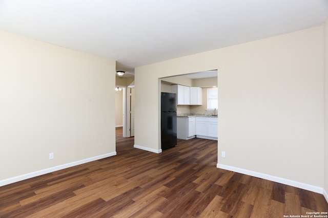 unfurnished living room featuring dark hardwood / wood-style floors and sink