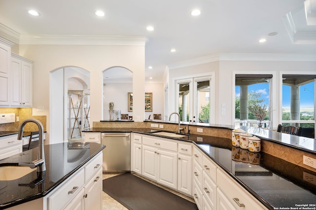 kitchen featuring crown molding, dark stone countertops, sink, dishwasher, and white cabinetry