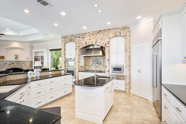 kitchen with a center island with sink, appliances with stainless steel finishes, and white cabinets