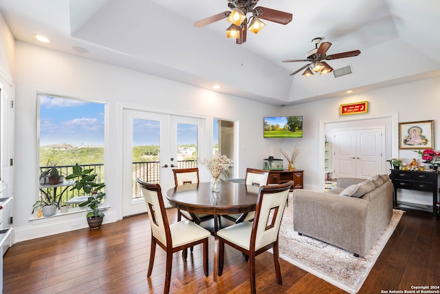 dining area featuring ceiling fan, a tray ceiling, and dark wood-type flooring