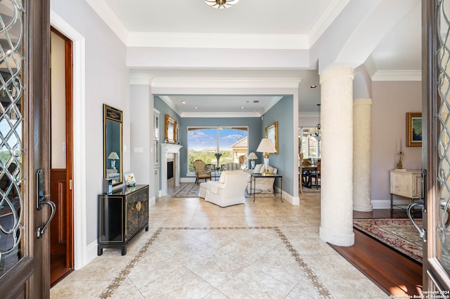 tiled entrance foyer featuring crown molding and decorative columns