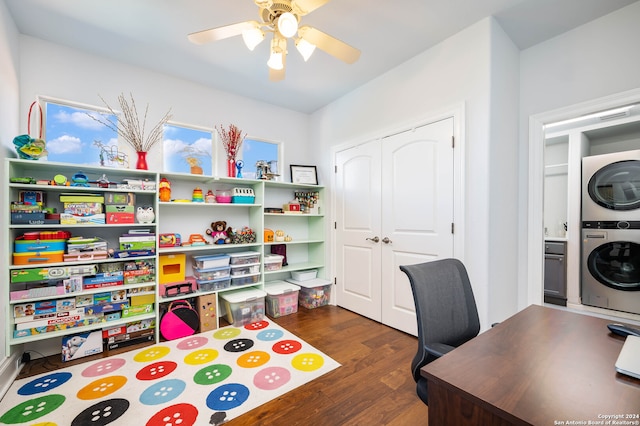 home office with dark wood-type flooring, stacked washing maching and dryer, and ceiling fan