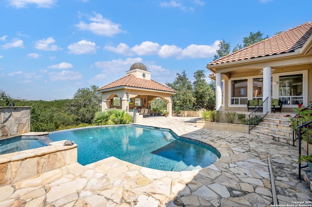 view of pool featuring an in ground hot tub, a gazebo, and a patio area