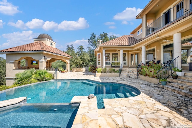 view of pool with ceiling fan and a patio